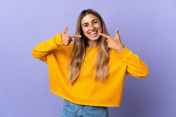 Young hispanic woman over isolated purple background giving a thumbs up gesture