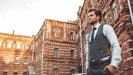 a man stands near a brick house