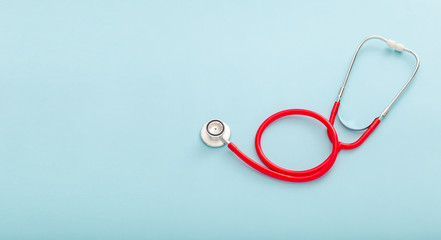 Red stethoscope on blue color background. Concept of medicine and health care Pulmonology Cardiology . Top view copy space for text. Long web banner