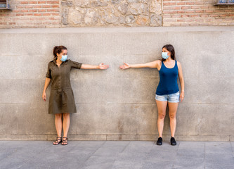 Obraz na płótnie Canvas two woman keeping social distancing. Coronavirus COVID-19 protection