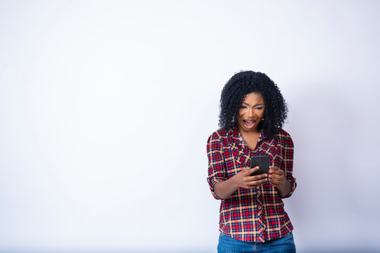 Young Black Woman Looking At Her Phone Feeling Worried