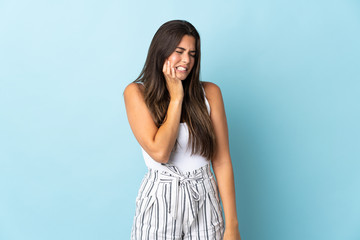 Young brazilian woman isolated on blue background with toothache