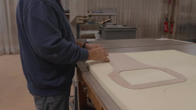 Worker drawing pattern on upholstery foam slowmotion, 4