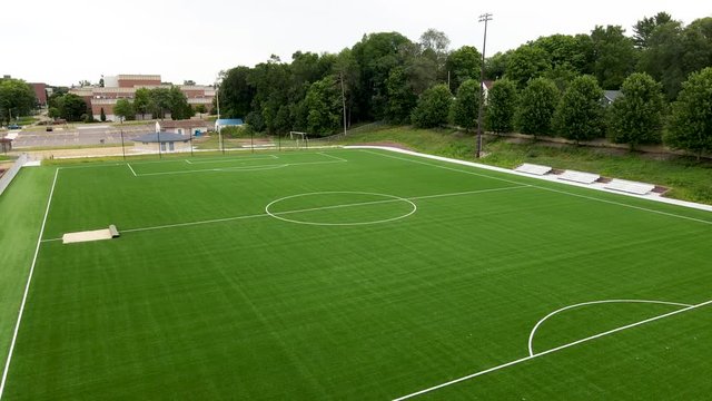 Rotating aerial view of well maintained and mowed soccer field at University of Wisconsin–Stout  in Menomonie, Wisconsin.