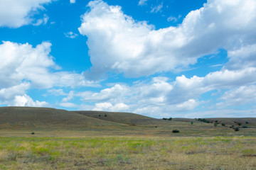 Obraz premium Beautiful landscape. Hills and bright blue sky with white clouds. Summer time concept, nature, selective focus