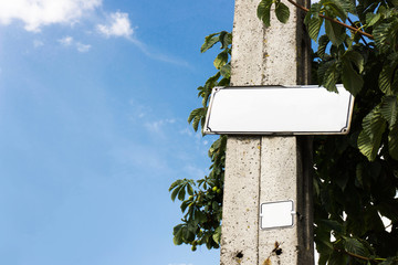 Street name empty copy space sign. Blank metal board attached to concrete pole. Outdoor text space frame.