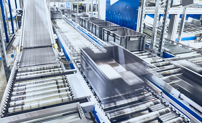 Modern conveyor system with boxes in motion, shallow depth of field.