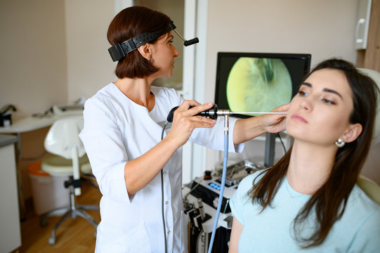 Female ent doctor and patient in chair, otoscope