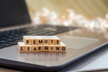REMOTE LEARNING virtual learning concept with wood block letters on laptop.  Distance learning,...