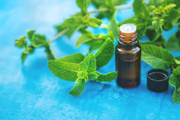 Peppermint essential oil in a small bottle. Selective focus.