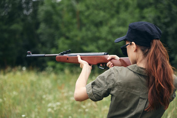 Woman Holds aiming hunting green overalls 