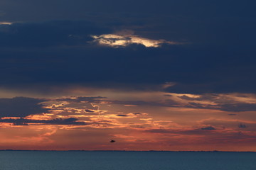 Hunstanton beach sun set over the sea ,glowing deep orange ball of fire 