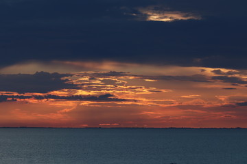 Hunstanton beach sun set over the sea ,glowing deep orange ball of fire 
