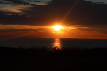 Hunstanton beach sun set over the sea ,glowing deep orange ball of fire 