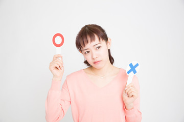 丸バツプレートを持つ女性