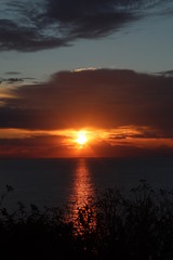Hunstanton beach sun set over the sea ,glowing deep orange ball of fire 