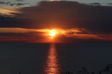 Hunstanton beach sun set over the sea ,glowing deep orange ball of fire 