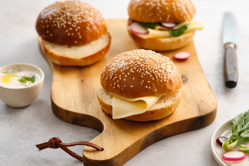 Sandwiches for lunch. Sandwich with cheese and herbs in a burger bun. Copy space.