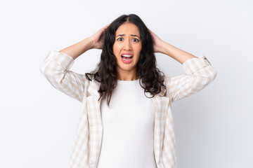Naklejka premium Mixed race woman over isolated white background frustrated and takes hands on head