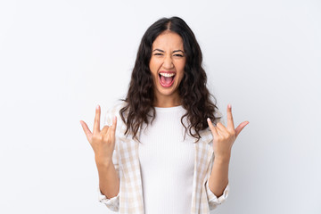 Mixed race woman over isolated white background making rock gesture