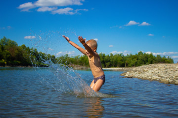 Fototapeta na wymiar boy bathes in a mountain river