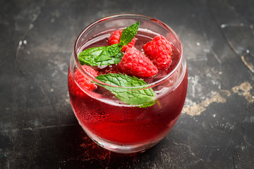 Raspberry and mint cocktail in glass on the rustic background. Selective focus. Shallow depth of field.