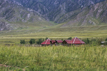Small hexagonal log cabins for tourists stand against the backdrop of the mountain slopes. Travel...