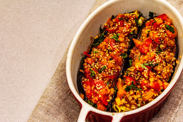 Karniyarik traditional Turkish food from stuffed eggplants with minced meat, tomato, greens and sesame seeds