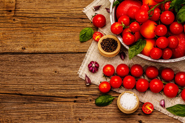 Assorted ripe multicolored tomatoes. Young garlic, fresh basil leaves, salt, spices