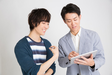 タブレットPCを見る男性 © Paylessimages