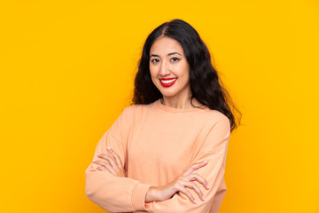 Obraz premium Spanish Chinese woman over isolated yellow background with arms crossed and looking forward