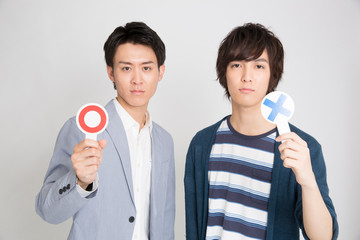 丸バツプレートを持つ男性