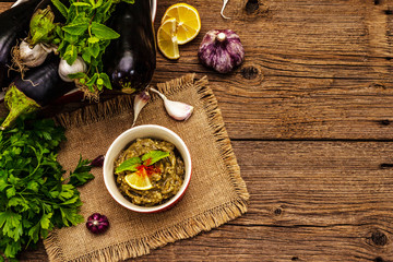 Eggplant dip baba ganoush (mutabbal) or mezze with ripe vegetables and fresh herbs
