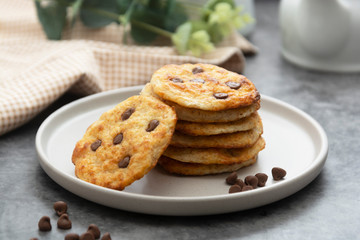 Stack of chocolate chip cookies. Dark background. Sweet delicious snack.
