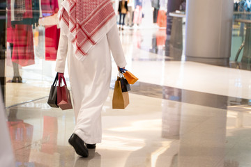 Arabic man holding shopping bags after buying some stuff from the mall