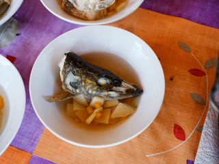Fish soup in a plate with a potato, spices and other components.