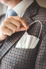Elegant man with protective mask as handkerchief in chest pocket.