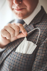 Elegant man with protective mask as handkerchief in chest pocket.