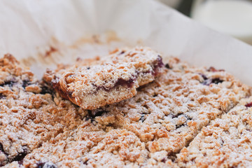 Crumble pie  filled with berries jam and powdered with glaze sugar. Close up view and selective focus.