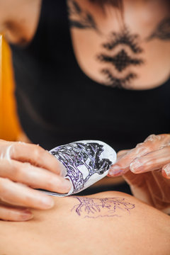 Tattooist Removing Stencil from a Client`s Arm