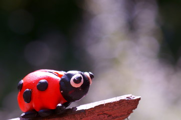 Figure of a ladybug on a purple background.