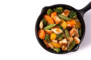 Stir fry chicken with vegetables on iron pan isolated on white background. Top view. Copy space
