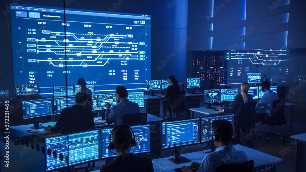 Poster Team of Professional Computer Data Science Engineers Work on Desktops with Screens Showing Charts, Graphs, Infographics, Technical Neural Data and Statistics. Low Key Control and Monitoring Room.
