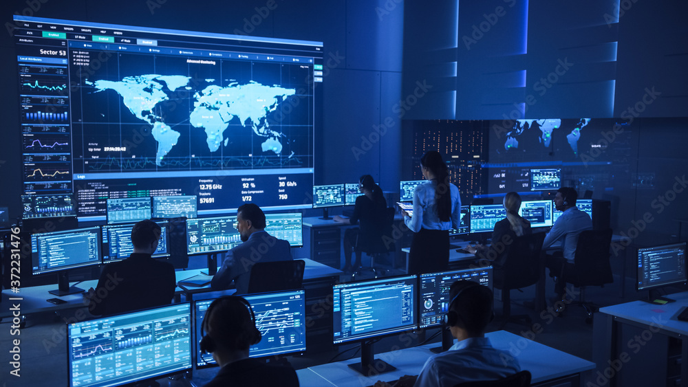 Poster Team of Professional Computer Data Science Engineers Work on Desktops with Screens Showing Charts, Graphs, Infographics, Technical Neural Data and Statistics. Low Key Control and Monitoring Room.