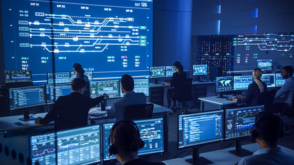 Team of Professional Computer Data Science Engineers Work on Desktops with Screens Showing Charts,...