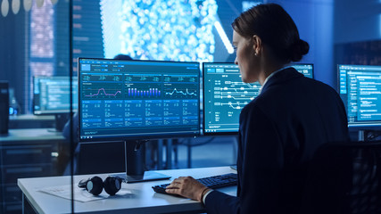 Confident Female Data Scientist Works on Personal Computer in Big Infrastructure Control and...