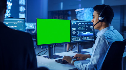 Confident Male Data Scientist Works on Personal Computer with Green Screen Template Wearing a...