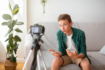Teen blogger sharing his opinion with followers, shooting home video