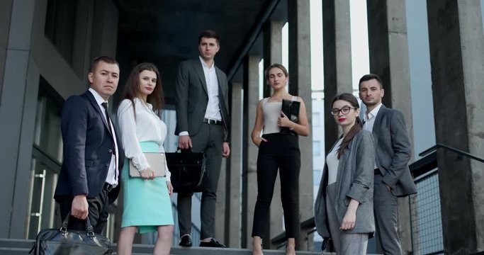 Portrait of successful creative businessman and businesswoman wear formal suits looking at camera and smiling in modern office workplace. Diverse male and female standing together