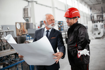 Colleagues working together. Arhitect and worker in factory..